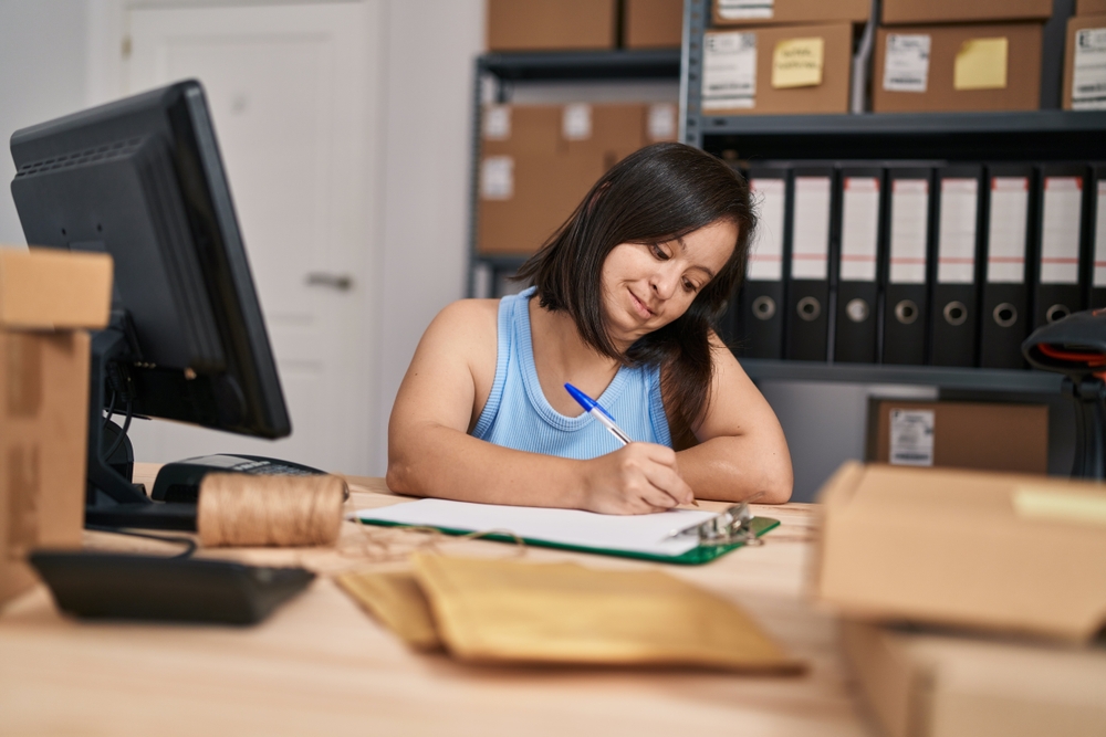 Records Management inventory work Team member organizing paperwork at a desk surrounded by storage boxes